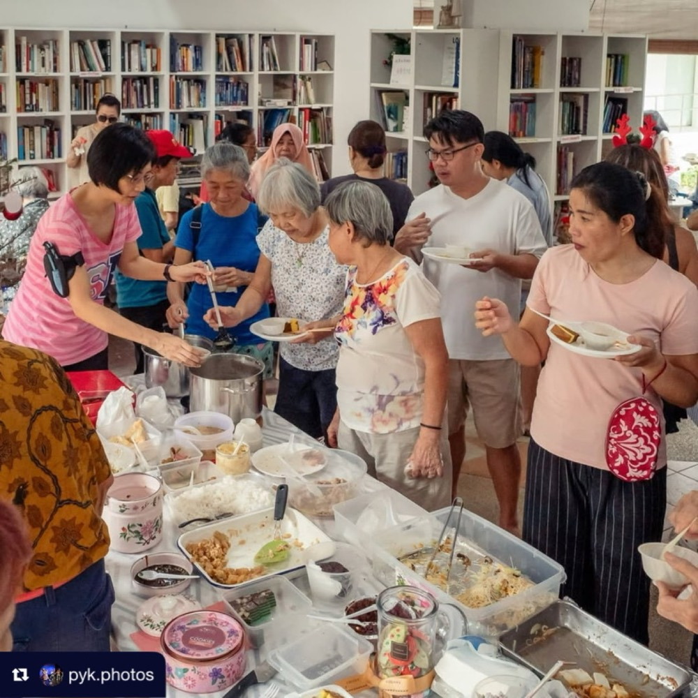 Neighbours choosing dishes together at a crowded potluck table