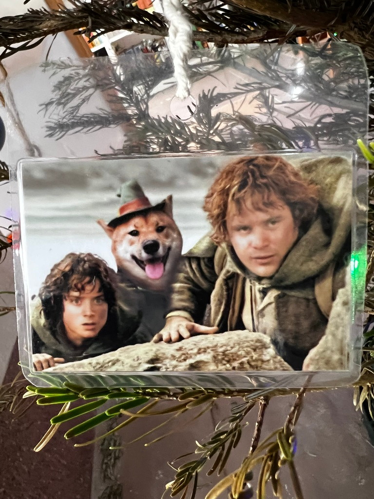 A keepsake on Firby showing a smiling dog in a tiny hat between two fantasy-film characters